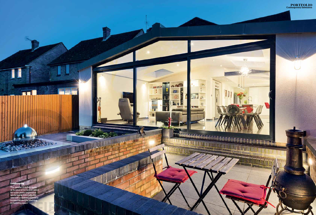 Night photograph of patio and rear elevation of new home extension.