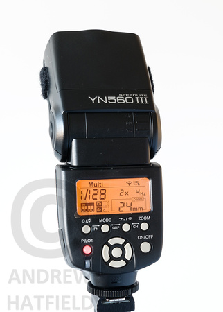 Photography of the Yongnuo YN560 Speedlite turned on and set to 1/128 power